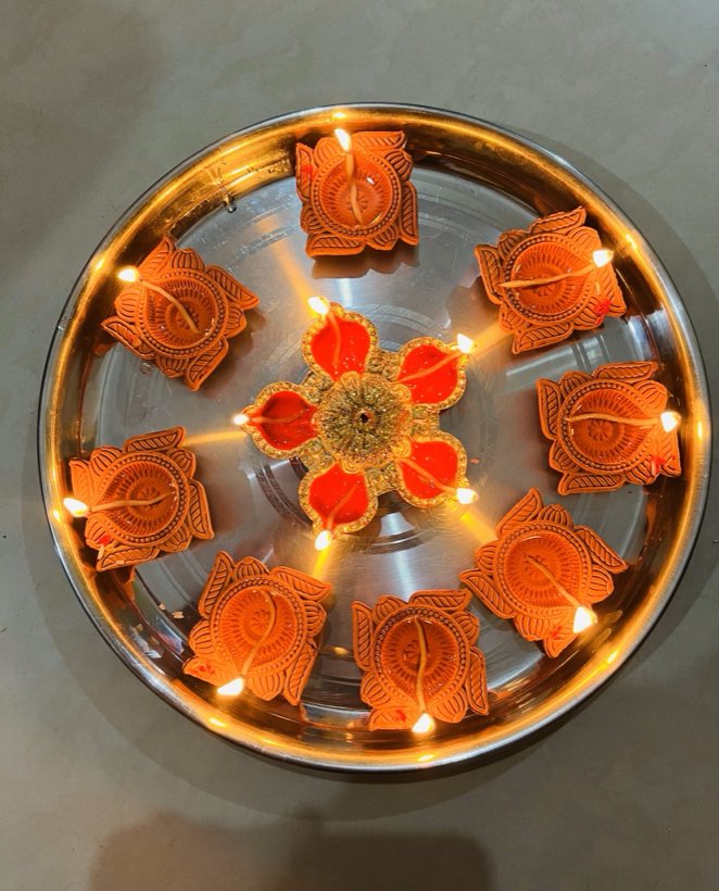 Oil lamps and marigolds on a brass thali