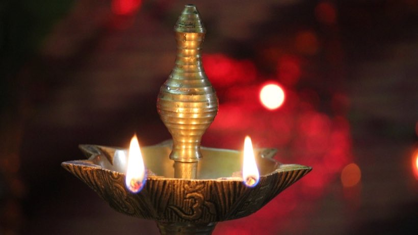 Lit brass oil lamp