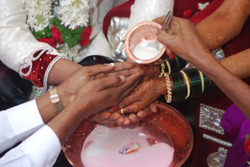Hands pouring from a kalash during a ceremony